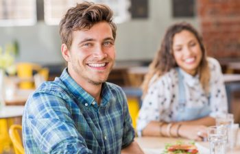 A happy broadly smiling man and woman having lunch